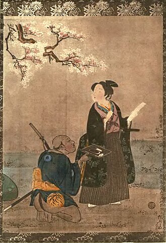 A young figure in a long black robe holds a sheet of poetry beneath cherry blossoms while a kneeling attendant offers an inkstone on a tray